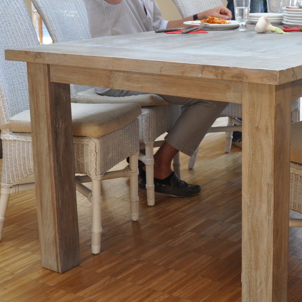 Detail Aufnahme von der Seite vom Esstisch aus Teakholz in massiver Ausfuehrung, Teak Massivholz Esstisch Barli mit robusten, starken Tisch Beinen aus Edelholz Teak massiv, Loom Stuehle in der Farbe Weiss, Massivholz Moebel nach Mass, Muenchen Moebel