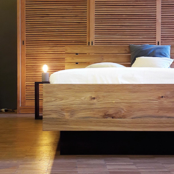 Elegantes Bett Wunder aus Massivholz Teak mit Bettkasten und Stauraum, Dekoration ist ein Teak Massivholz Schrank, eine Lampe fuer Beistelltisch oder Nachttisch, edles bicolor Massivholzbett im modernen Design in der MOEBEL KOLONIE Manufaktur vom Schreiner in Handarbeit gefertigt, unser Schreiner zimmert auch individuell nach Mass fuer Ihr Schlafzimmer, das Kopfteil hat Streben aus Metall, Moebel Muenchen Teak Massivholz