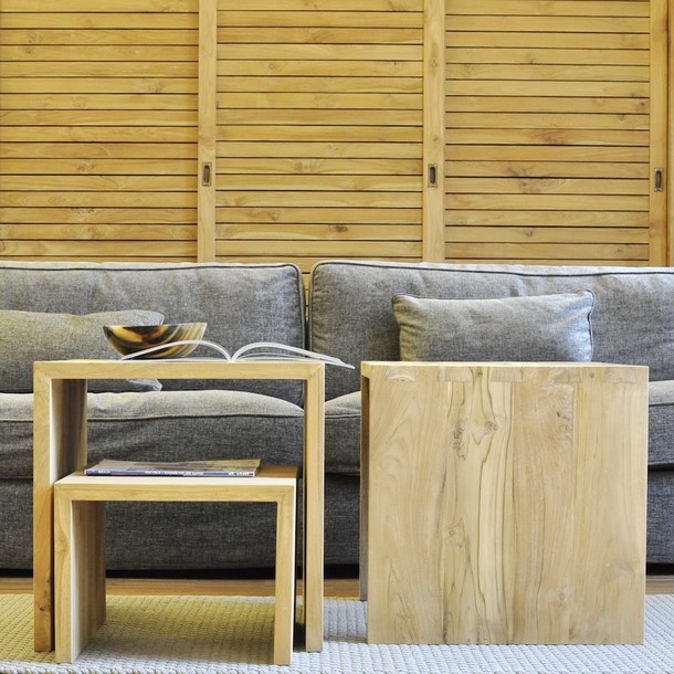 Massivholz Couchtisch U aus zertifiziertem Teak, Edelholz Teak Sofa Tisch in verschiedenen Groessen vom Schreiner in Handarbeit gefertigt, Couchtisch in modernem Design, auch als Hocker einsetzbar, im Hintergrund komfortables Sofa in der Farbe Antik und ein Kleiderschrank aus Teak Massivholz, Massivholz Moebel nach Mass Muenchen