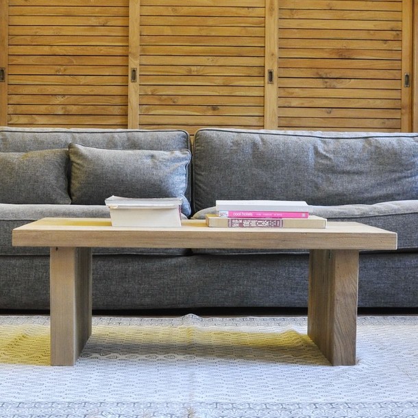 Moderner Couchtisch Japan aus Massivholz Teak im Asia Style, Front Ansicht vom Teakholz massiv Sofa Tisch, vom Schreiner traditionell in Handarbeit gefertigt, Dekoration ist ein Sofa im modernen Design in der Farbe Anthrazit, Accessoires Buecher und ein schoener Teppich in den Farben Weiss und Grau, Wohnen wie im Urlaub Muenchen